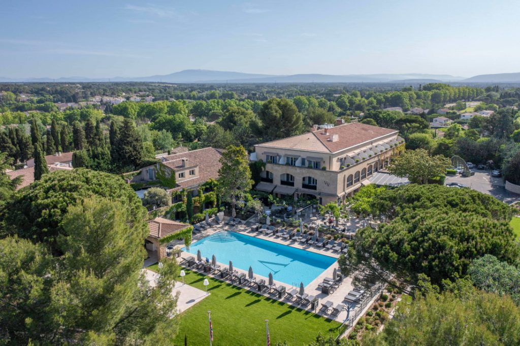 Vue panoramique de l'hôtel 4 étoiles du Vallon de Valrugues comportant une piscine extérieure et intérieure ainsi qu'un spa