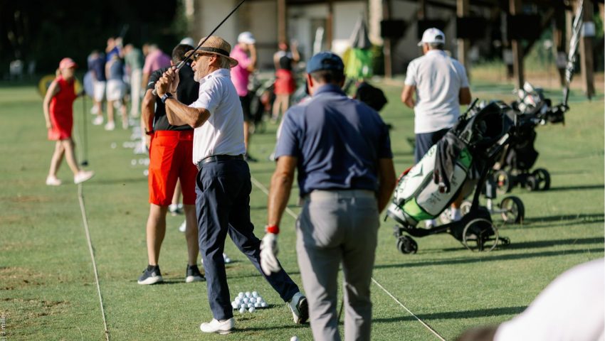 Golfeurs s’entraînant au practice avec un seau de balles et des baguettes d’alignement au sol.