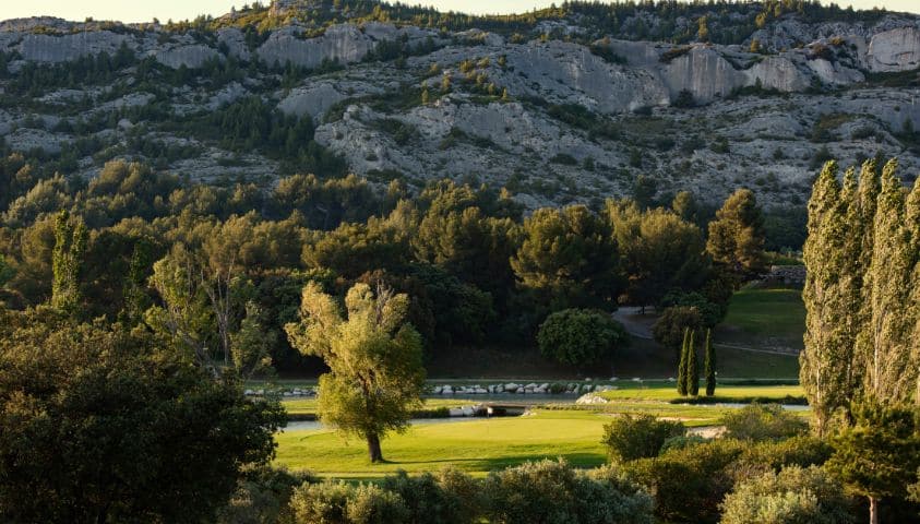 Parcours de golf provençal entouré d’oliviers et de collines en automne.
